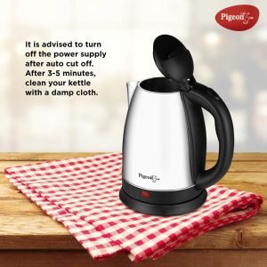 Automatically boiled electric kettle with black handle on a red checkered cloth, Pigeon brand, on wooden surface.