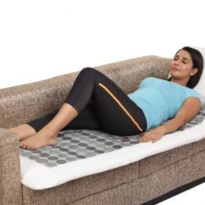 Comfortable woman resting on sofa with cooling gel mattress topper for optimal sleep comfort.
