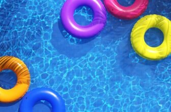 Bright colorful inflatable pool rings floating on a sparkling blue pool, perfect for summer pool party fun. Enjoy relaxing and swimming with vibrant pool accessories on sale now.
