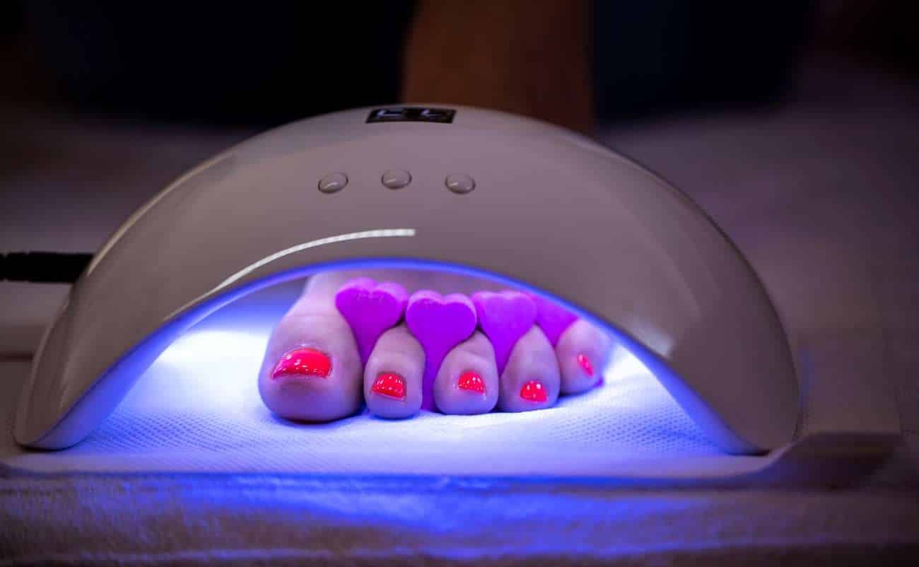 Gel nail curing lamp with purple LED lights for professional manicures, fast drying, and high-quality nail polish application.
