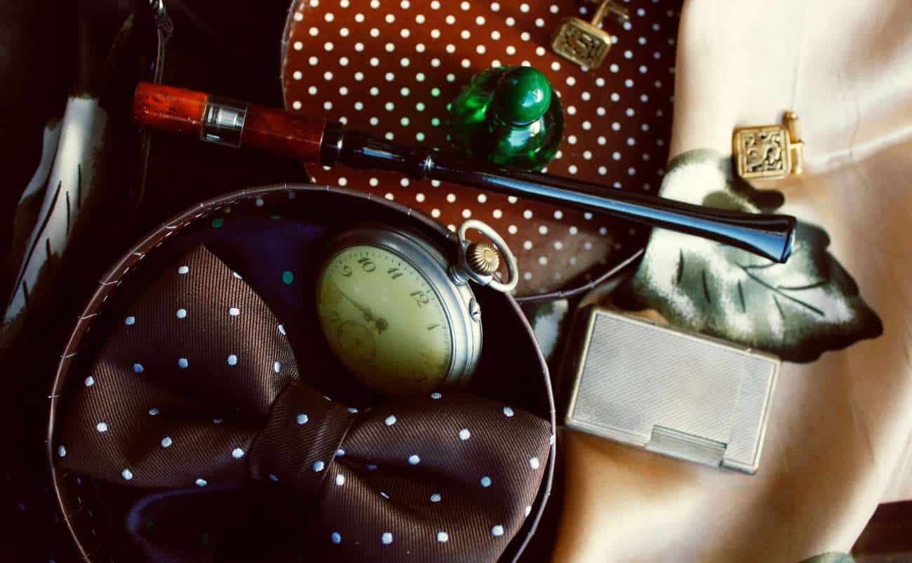 Silk polka dot bow tie, vintage pocket watch, fountain pen with wood and black accents, decorative perfume bottle, gold clasp cosmetic case, sale is live promotional image for exclusive fashion accessories and elegant lifestyle items, perfect for online shopping deals.