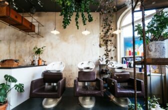 Modern hair salon with washing stations featuring comfortable chairs, lush indoor plants, stylish decor, and ample natural light for a relaxing salon experience.