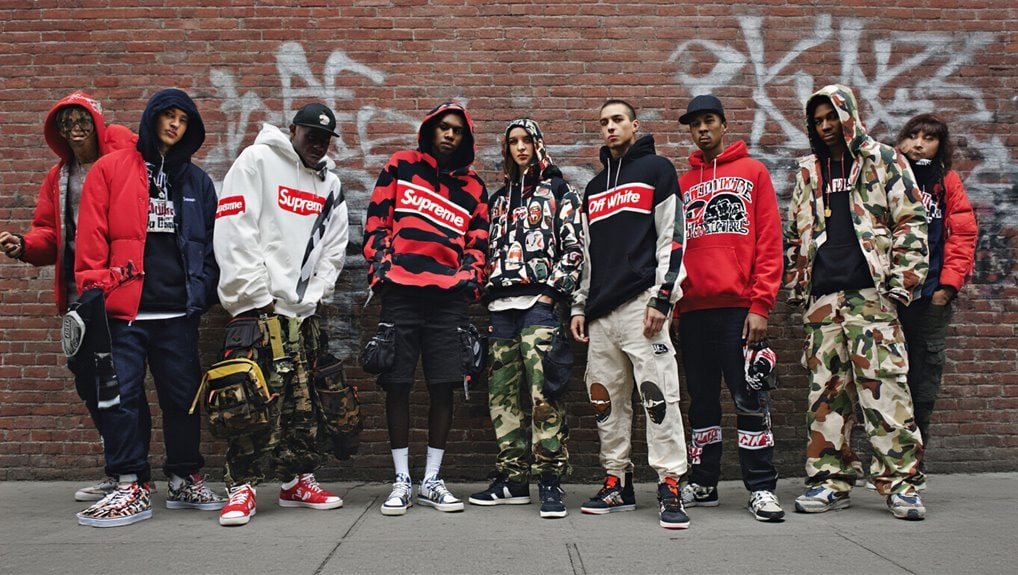 Bold urban streetwear models showcasing trendy hoodies, joggers, and sneakers in a graffiti-covered city setting, emphasizing Sale is Live's latest fashion deals and street style.