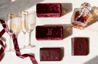 Luxurious YSL leather wallets and personalized cases with monogram details, accompanied by champagne flutes and a crystal decanter on a marble surface, perfect for elevating your fashion and gift experiences.
