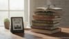 Books and Kindle e-reader on a wooden desk with a window in the background.
