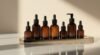 An array of amber glass dropper bottles containing high-end skincare serums and oils, arranged on a sleek, modern tray with soft natural lighting highlighting their elegant design.